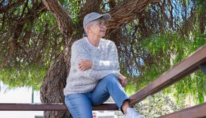 smiling-senior-woman-with-cap-glasses-cozy-sweater-enjoying-quiet-sunny-day-outdoors_465191-14097_11zon-min